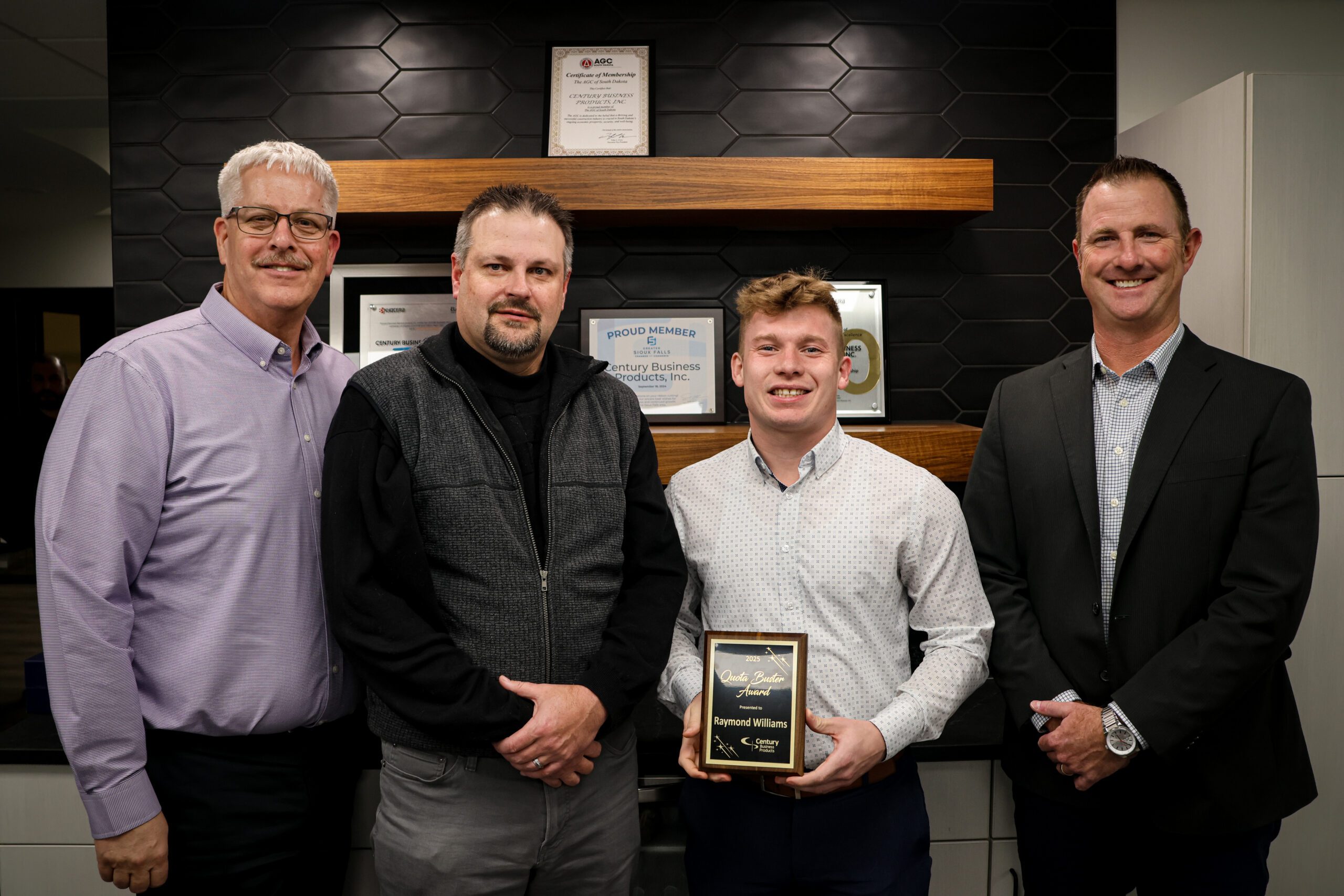 Photo of Kevin Jergenson, Mike Satter, Raymond Williams (holding an award), and Ryan Majors