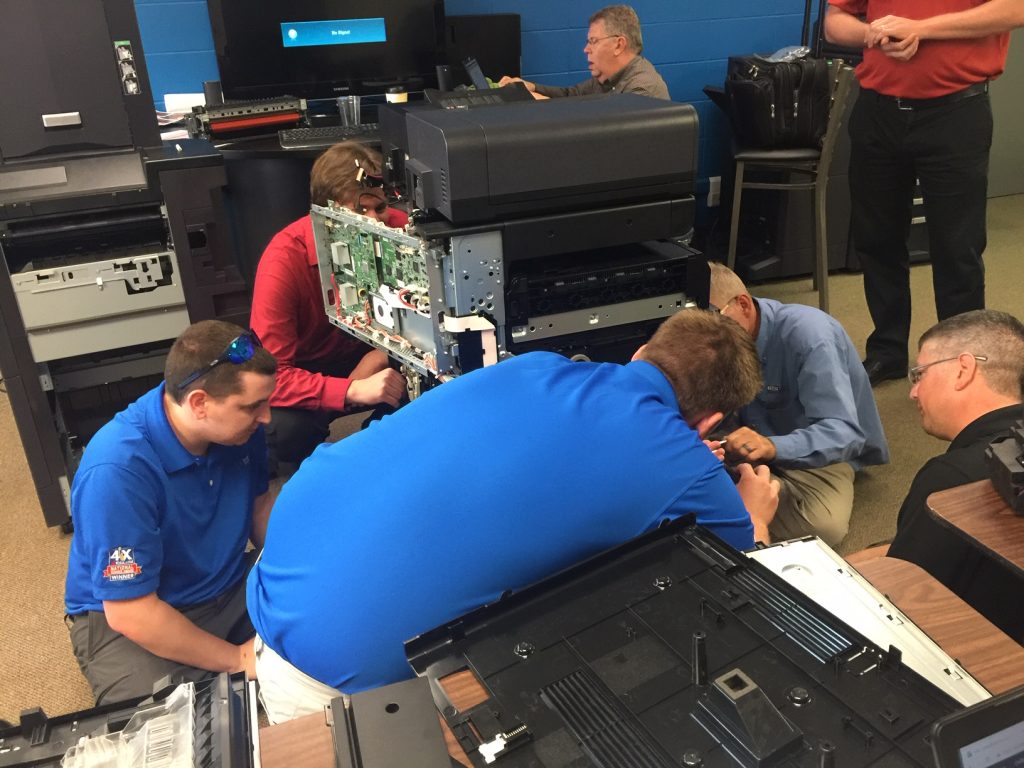 technicians take apart copiers